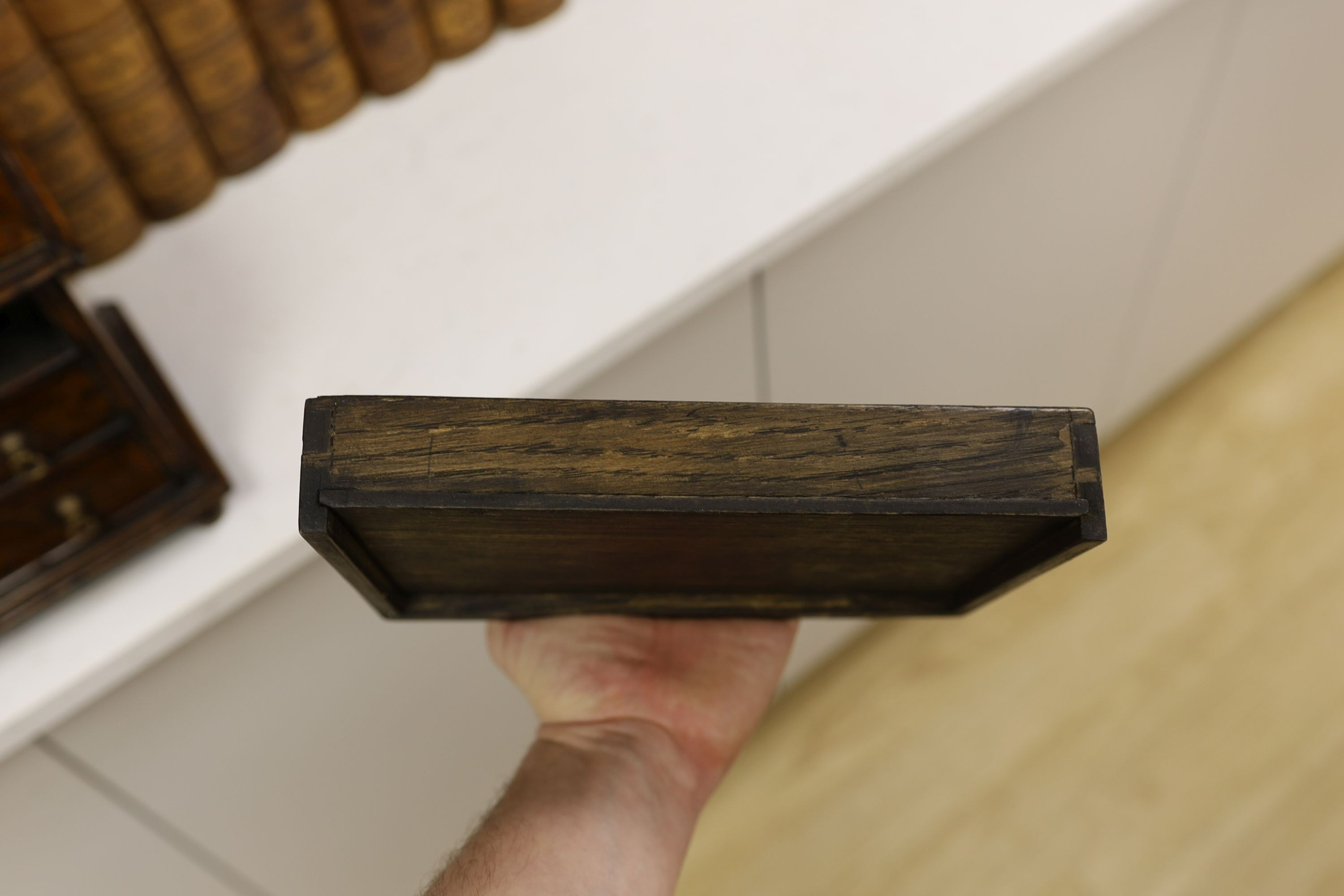 A cross banded walnut miniature chest of three drawers, 26cm wide